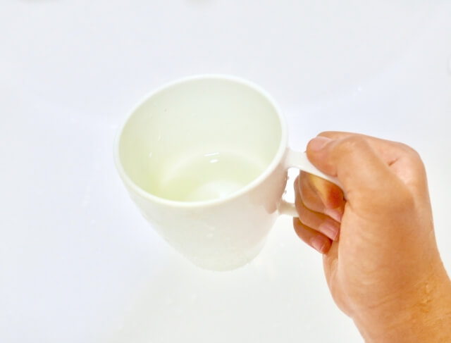 白いコップを持つ子ども