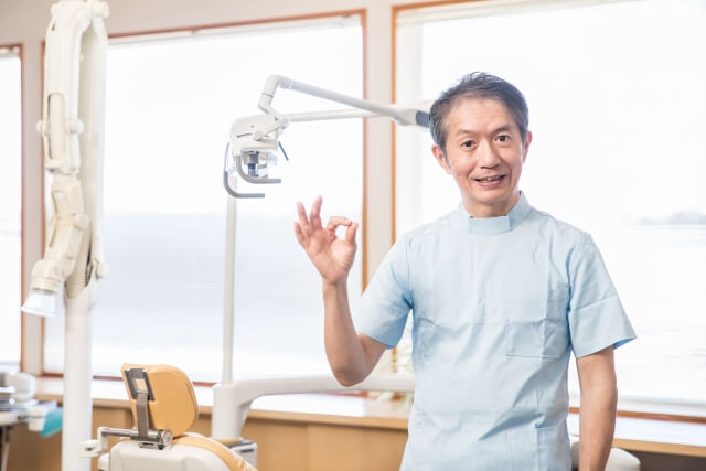 OKサインをつくる歯科医師
