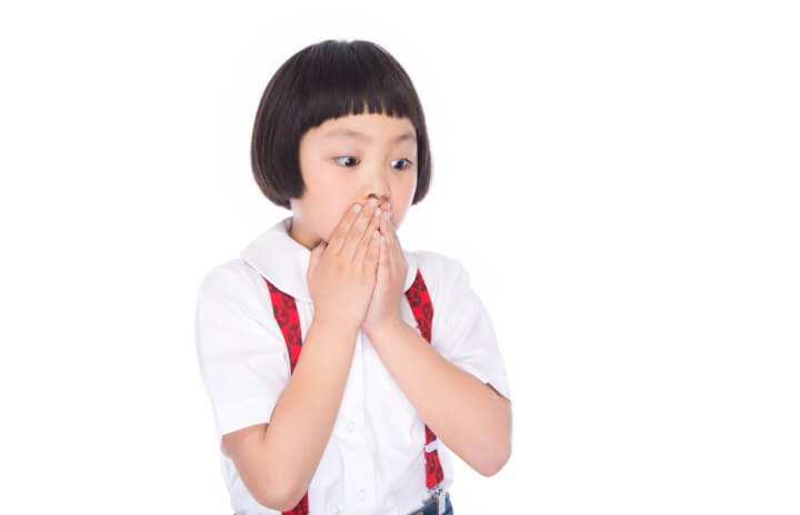 口に手をやる子ども